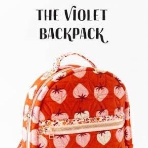 May include: An orange quilted backpack with a strawberry design, a zipped front pocket, and a top handle. The text "THE VIOLET BACKPACK" is at the top. The backpack has a floral patterned strap and a "KNOT + THREAD design" logo.