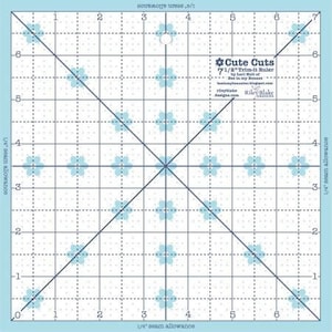 May include: A blue and white quilting ruler with a grid pattern and a flower design. The ruler is labeled "Cute Cuts 7 1/2" Trim-it Ruler by Lori Holt for Riley Blake Designs".