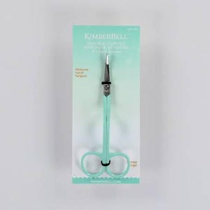 May include: A light blue pair of double-curved applique scissors with a silver blade. The scissors are packaged on a white card with the text "KIMBERBELL. DOUBLE-CURVED APPLIQUE SCISSORS 6" (15cm) Blades" and "Reduces hand fatigue!" printed on it.