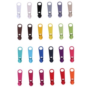 Może przedstawiać: Zestaw 24 suwaków do zamków błyskawicznych w różnych kolorach, w tym białym, czarnym, szarym, żółtym, brązowym, niebieskim, zielonym, czerwonym i różowym. Suwaki do zamków błyskawicznych są wykonane z tworzywa sztucznego i mają prosty, funkcjonalny design.