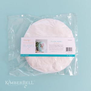 May include: A white round pillow insert in a clear plastic bag. The bag has a label that says "Kimber Blanks Pillow Insert 12" Round".