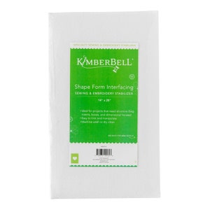 May include: White Kimberbell Shape Form Interfacing, a sewing and embroidery stabilizer. The package has a green label with the text "Shape Form Interfacing" and measurements of 14" x 28". The product is designed for projects needing structure, easy to trim, and machine washable.