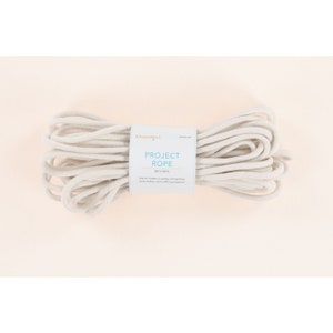 May include: A white cotton rope labeled "Project Rope" by the brand "Kemberdell". The rope is 1/4" thick and 100 ft long. It is used for machine embroidery and crafting projects.