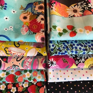 以下が含まれることがあります： 様々なパターンが施された10枚の布の正方形の積み重ね。パターンには、花柄、水玉模様、ティーカップ、イチゴ、ブルーベリーなどがあります。布の正方形は、青、ピンク、黄、白、黒など、さまざまな色です。