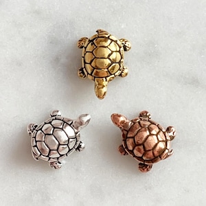 May include: Three small turtle figurines, one gold, one silver and one copper.