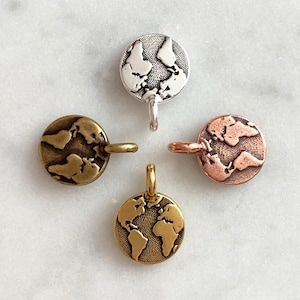 May include: Four metal globe charms in different finishes: silver, brass, copper, and gold. Each charm features a detailed world map design.