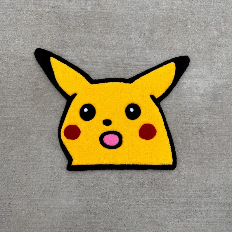 May include: A yellow character rug with black outlines, black eyes, red cheeks, and a pink mouth.