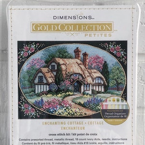 May include: A cross stitch kit featuring a cottage with a thatched roof and a garden. The kit includes presorted thread, metallic thread, 18 count ivory Aida fabric, a needle, and instructions. The kit is 7 inches by 5 inches (17.7 cm x 12.7 cm).