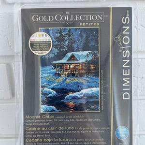 Könnte beinhalten: Ein Dimensions The Gold Collection Petites Moonlit Cabin Zählkreuzstich-Set in einer transparenten Kunststoffverpackung. Das Set enthält vorsortiertes Garn, 18-Count marineblauen Aida-Stoff, eine Nadel und eine Anleitung für ein 12,7 cm mal 17,7 cm großes Projekt.