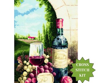 May include: A cross-stitch kit depicting a still life with a wine bottle, a glass of red wine, grapes, and cheese. The scene is set against an arched stone structure with a landscape background. The kit includes the text "CROSS STITCH KIT".
