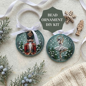 May include: Two circular bead ornament DIY kits featuring a nutcracker and a ballerina embroidered with beads on a green fabric background. Each ornament has a white ribbon loop. A wooden snowflake and nutcracker cutout are included.