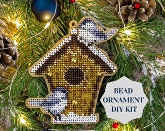 May include: A DIY bead ornament kit featuring a birdhouse with two birds, one perched on the roof and one sitting on the edge. The ornament is made of beads and is ready to be assembled.