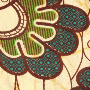 May include: A close-up of a fabric with a brown, green, and blue pattern. The pattern features a series of overlapping circles and leaves.