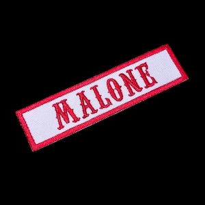 May include: White fabric patch with a red embroidered border and the word "MALONE" in red.