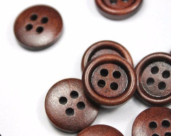 May include: A collection of dark brown wooden buttons with four holes each, scattered on a white surface. The buttons have a slightly raised rim and a smooth, polished appearance, suggesting they are new.