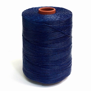 Op de afbeelding: Een spoel donkerblauwe gewaxt linnen draad.