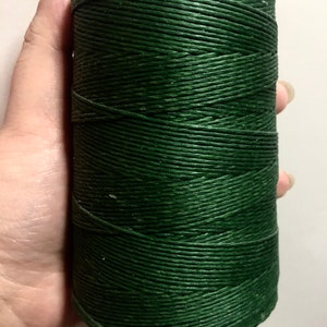 Puede incluir: Un carrete de cordón de lino encerado verde oscuro.