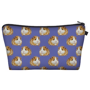 May include: A purple zippered makeup bag with a repeating pattern of brown and white guinea pigs.