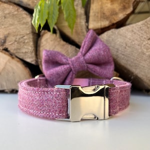 Puede incluir: Un collar para perro de tweed rosa con una pajarita a juego. El collar tiene una hebilla plateada y está hecho de una tela suave y cómoda.