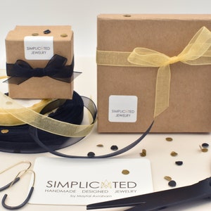 Simplicated Jewelry items arrive in a box tied with a bow, ready to keep or gift.