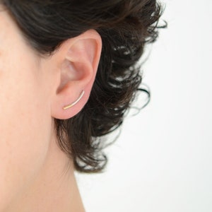 Modern and edgy thin climber earrings in 9k gold and sterling silver. First quarter is yellow gold and the rest silver a sleek slightly curved line to compliment the contour of your ear. Available as single earring or pairs. sexy delicate earring.
