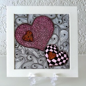 May include: A square art print featuring two large hearts against a background of black and white swirling lines. One heart is pink with a spiral pattern, the other is a pink and black checkerboard. Both feature a small orange heart accent.