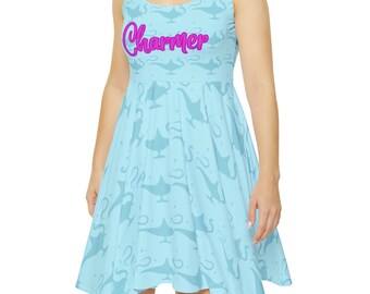 Puede incluir: Un vestido azul claro sin mangas con un patrón de lámparas de genios azules. La palabra "Charmer" está escrita en rosa en la parte delantera del vestido.