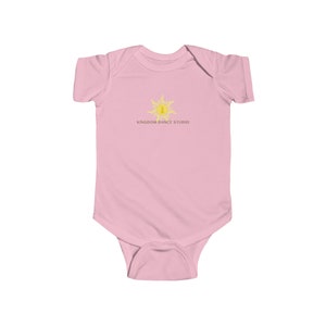 May include: Pink baby onesie with a yellow sun graphic and the text "Kingdom Dance Studio".