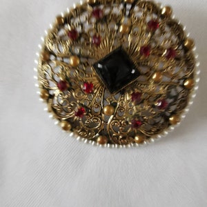 A Beautifully Detailed Filagree Style Brooch. Red Stones and Pearl Surround.