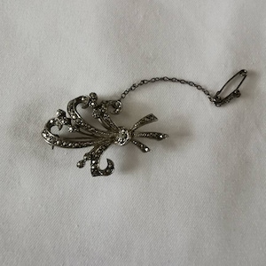 Small Silver Tone Marcasite Brooch with safety chain.