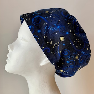 May include: A blue and gold patterned scrub hat with a swirling design. The hat is made of a soft, comfortable fabric and is perfect for nurses, doctors, and other healthcare professionals.