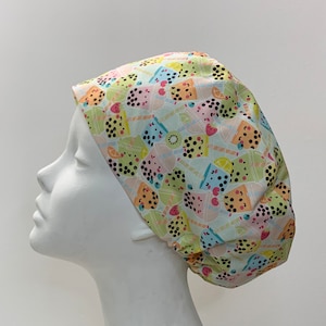 May include: A light blue and green patterned surgical scrub hat with a design of colourful bubble tea cups and fruit.
