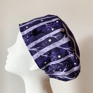May include: Purple and white striped scrub hat with a silhouette of a deer and trees. The hat has white stars scattered throughout the design.