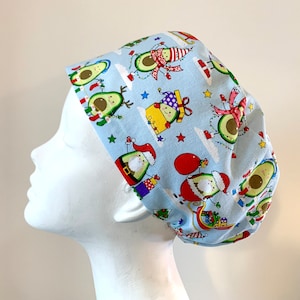 May include: A light blue scrub hat with a Christmas themed avocado print. The avocados are wearing Santa hats, reindeer antlers, and other festive attire.