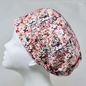 May include: A patterned skull cap with a repeating design of skulls in shades of red, pink, black, and white. The cap is made of a soft fabric and is designed to fit snugly on the head. The skull cap is shown on a white mannequin head.