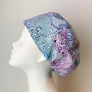 May include: A white scrub cap with a blue and purple paisley pattern.
