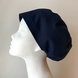 Peut inclure: Un bonnet de travail bleu foncé en tissu de coton. Le bonnet est conçu pour être porté par les professionnels de santé.