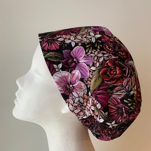May include: A black scrub hat with a floral print featuring pink, purple, and red flowers on a black background.