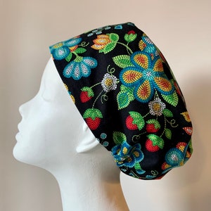May include: A black scrub hat with a floral pattern featuring colorful flowers and strawberries. The flowers are made of small, colorful beads.