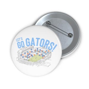 May include: White button with the text "LET'S GO GATORS!" in light blue. The button features a line drawing of a stadium with orange and blue seating. A second button is visible in the background.