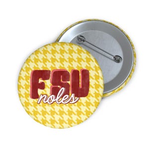 Peut inclure: Un bouton rond avec un motif pied-de-poule jaune. Le bouton affiche le texte "FSU noles" en rouge, avec un effet vieilli et un contour blanc. Le dos du bouton est argenté avec une épingle.