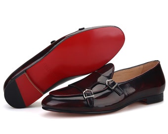 May include: Burgundy leather loafers with double buckles and a red leather sole.