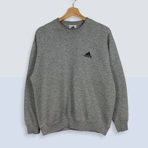 May include: A gray sweatshirt with a black Adidas logo on the front.