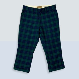 May include: Green and black plaid pants with a wide leg and a cuffed hem.