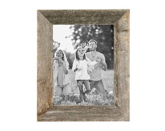 May include: A rustic wood picture frame with a black and white photo of a family playing in a field. The frame has a distressed wood finish and a wide border.