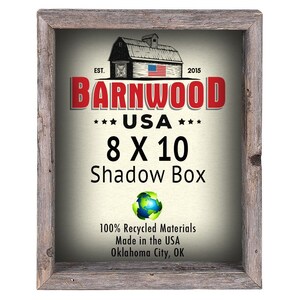 May include: A rustic wooden shadow box frame with a white background and red text that reads "BARNWOOD *** USA *** 8 X 10 Shadow Box". The frame is made from 100% recycled materials and is made in the USA. The text also includes "EST. 2015" and a small image of a red barn with an American flag.