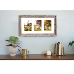 May include: A rustic wood picture frame with three openings, each holding a photo of a family in a grassy field. The frame is hanging on a light blue wall.