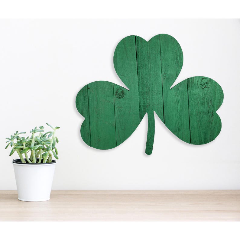 May include: A green shamrock cutout made of wood with a rustic wood grain texture. The shamrock is a popular symbol of Irish culture and is often used as a decoration for St. Patrick's Day.