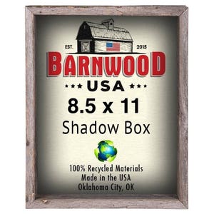 May include: A rustic wooden shadow box frame with a red, white, and blue barnwood logo. The logo says "Barnwood" with "USA" and "8.5 x 11" underneath. The frame is made from 100% recycled materials and is made in the USA.