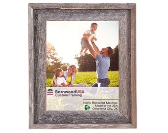May include: A rustic wood picture frame with a gray weathered finish. The frame is made from 100% recycled material and is made in the USA. The frame is labeled "BarnwoodUSA Custom Framing" and "Oklahoma City, OK".